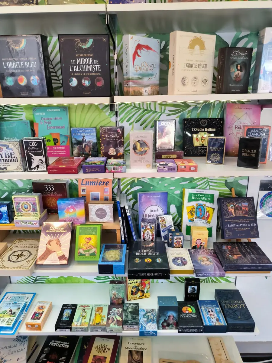 Étagères garnies de jeux d'oracles, de tarots et de livres spirituels