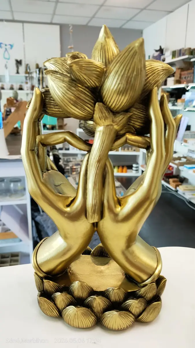Statuette dorée de mains croisées portant un bouton de lotus