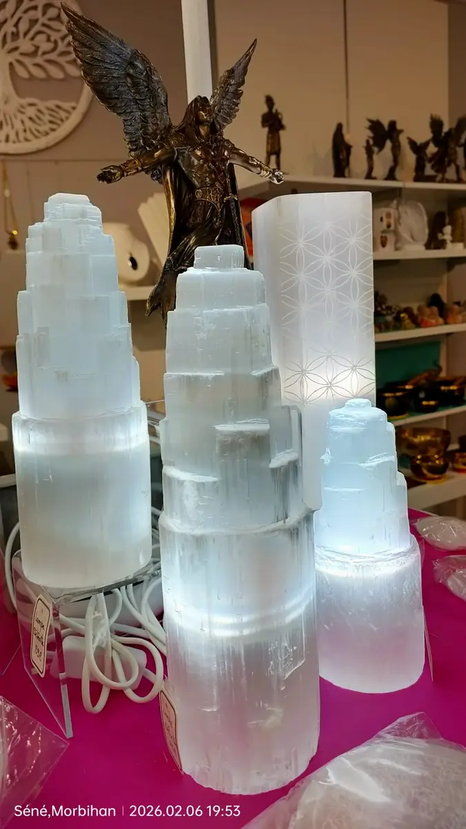 Lampes en sélénite naturelle illuminées près d'une statuette d'ange